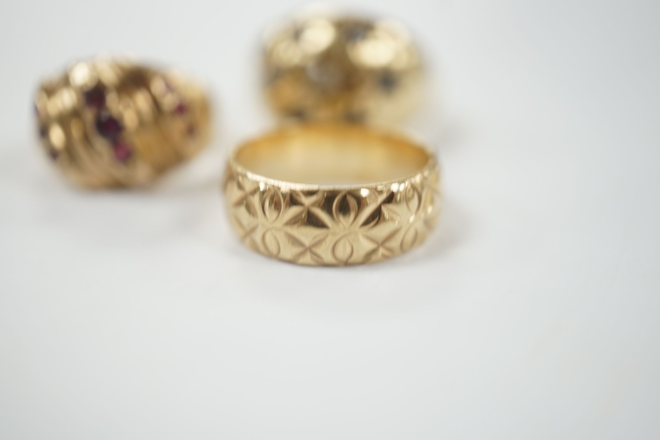 Two modern 9ct gold and gem set dress rings and a similar engraved 9ct gold band